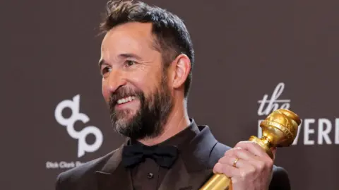 Reuters Noah Wyle holding up his Golden Globe