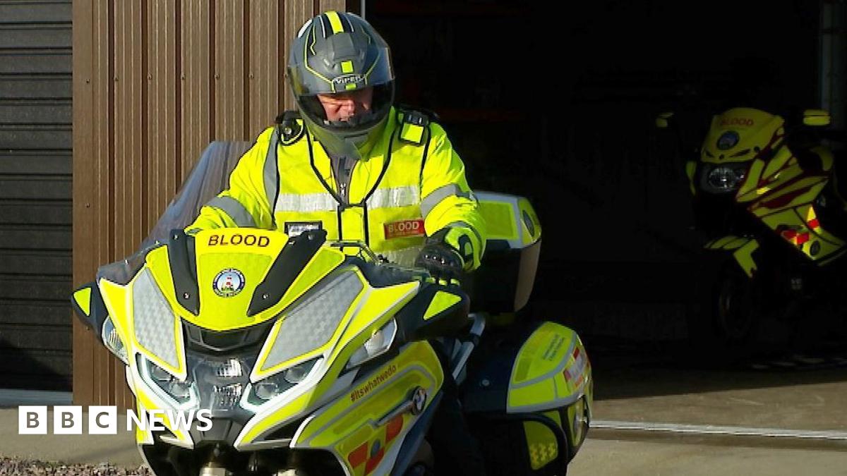 A south west blood bike rider sat on a motorbike in front of the charity's Devon headquarters in Plymouth