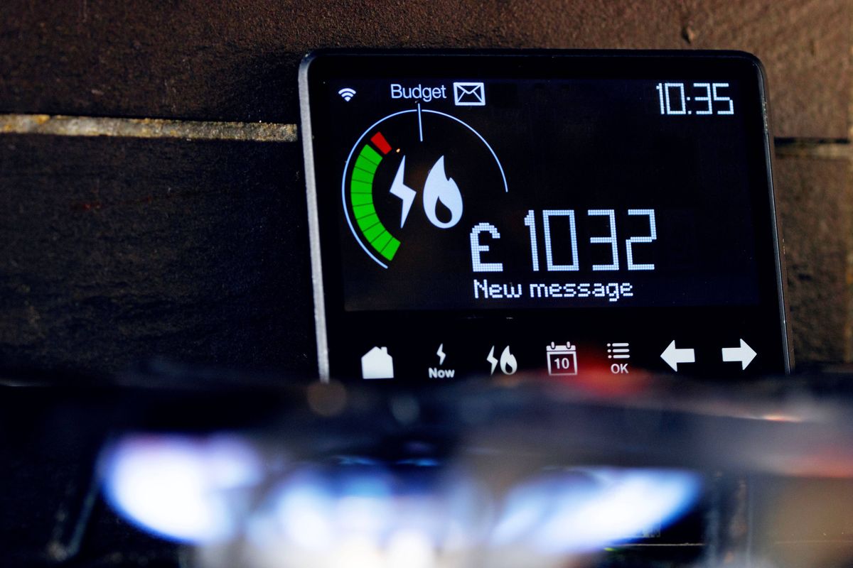 Close up of 'smart meter' showing sign of electricity and gas energy usage behind illuminated cooker