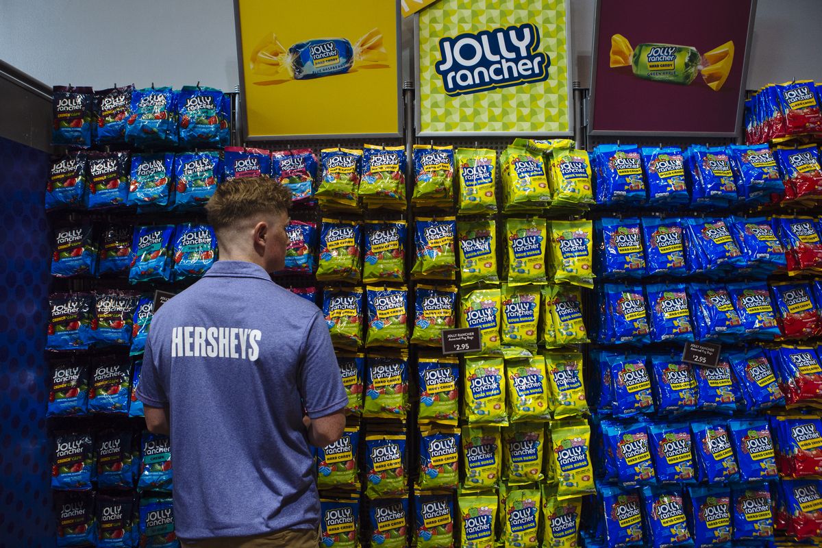 An employee arranges bags of Hershey Co. Jolly Rancher brand candy at the Hershey Chocolate World store in Hershey, Pennsylvania, U.S., on Friday, July 13, 2018. 
