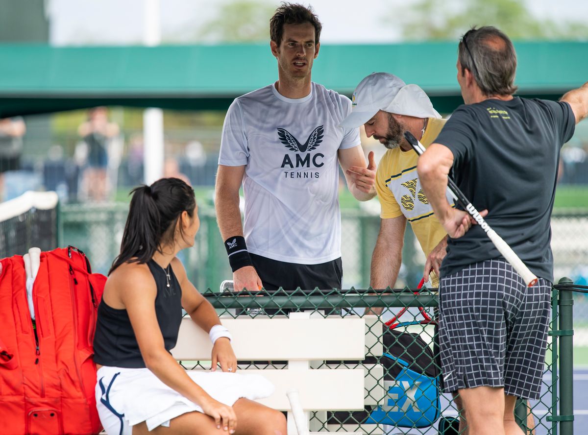 Emma Raducanu of Great Britain talks to Andy Murray of Great Britain after practicing with her temporary coach Jeremy Bates of Great Britain at the Indian Wells Tennis Gardens on October 07, 2021 in Indian Wells, California.