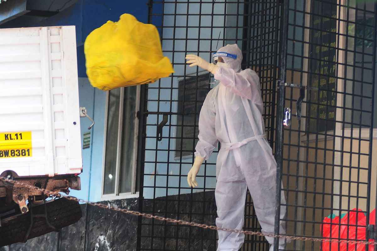 A health worker wearing protective gear disposes biohazard waste from a Nipah virus isolation center at a goverment hospital in Kozikode, in India's southern state of Kerala on September 16, 2023. 