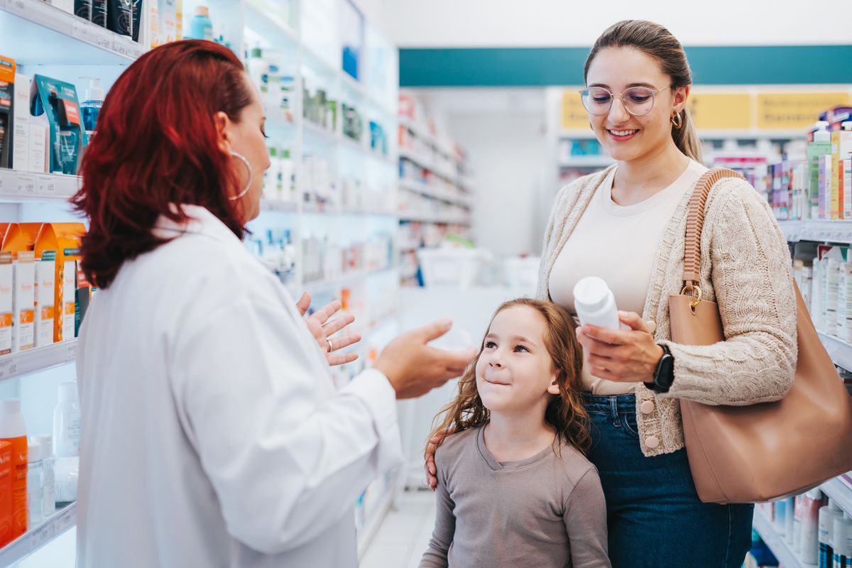 Female pharmacist assisting a mother with her daughter