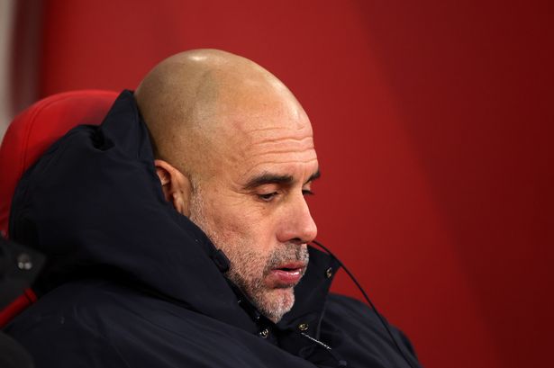 Pep Guardiola puffs his cheeks in the dugout.