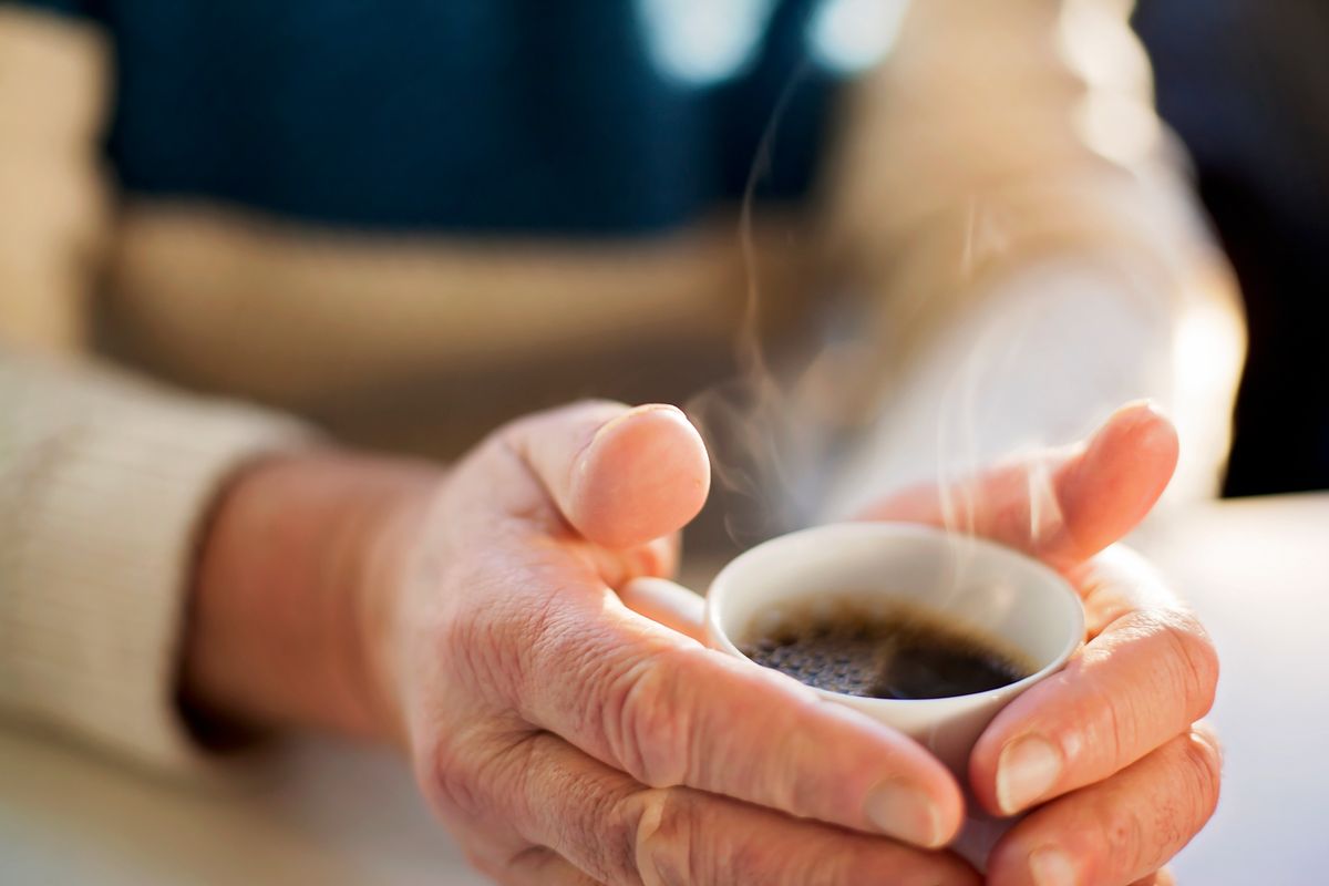 Elderly person holding cup