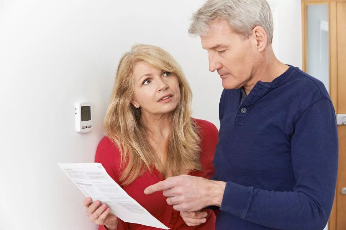 A worried looking couple examining a bill