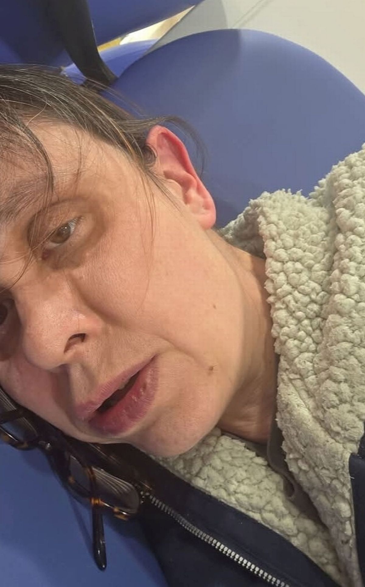 Clare Garrett laying down on chairs in a waiting room