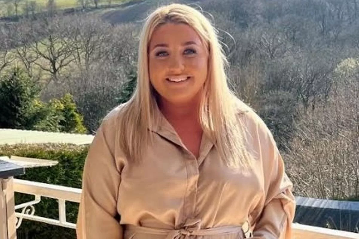 A blonde woman smiling in a dress