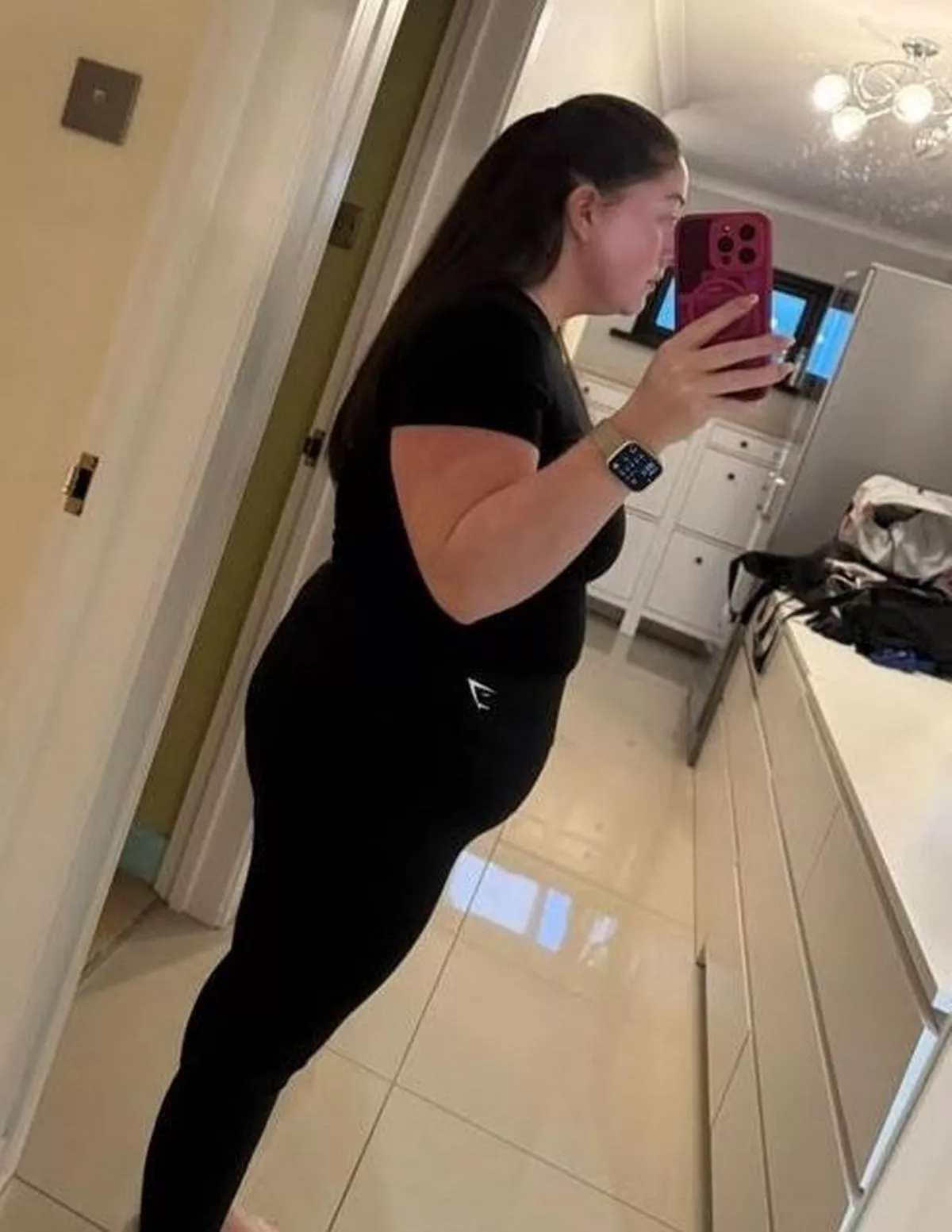 A dark-haired woman in black gym gear