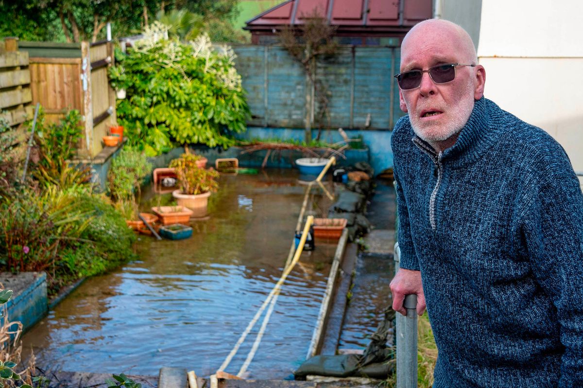 Terry Roch pictured in his flooded back garden