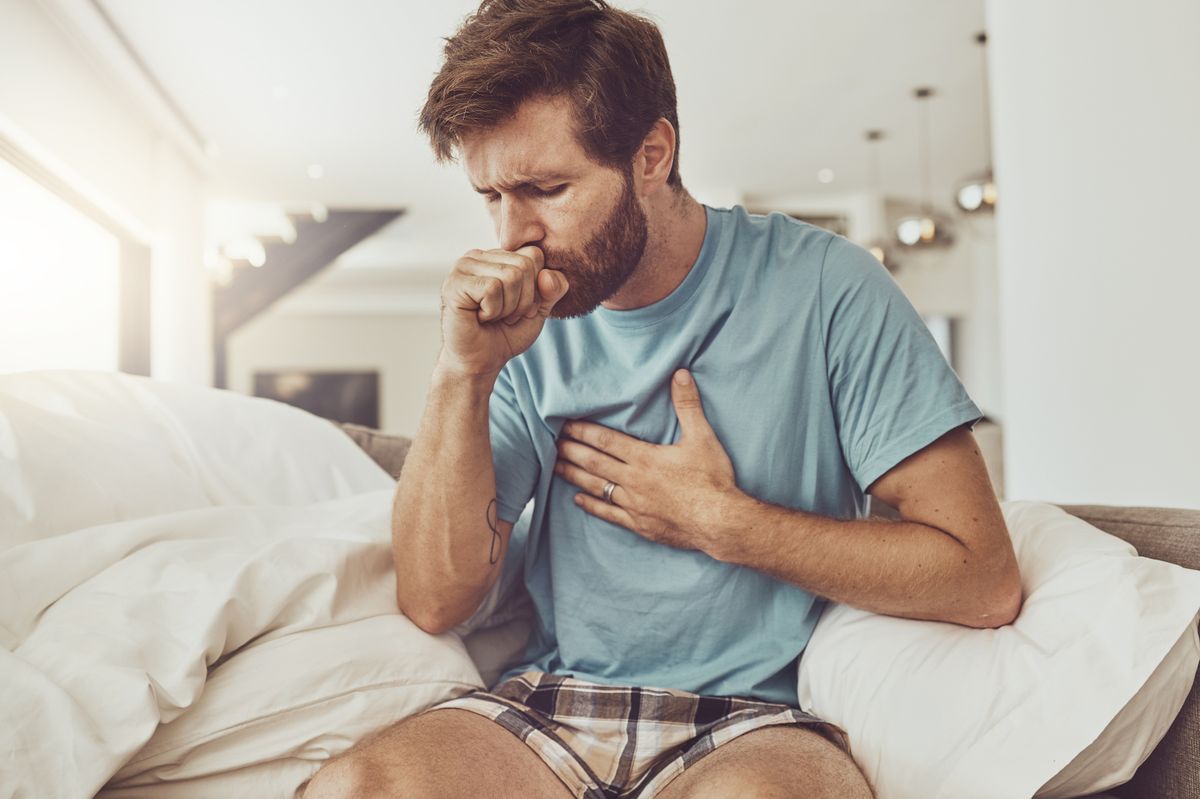 Male patient coughing into their hand