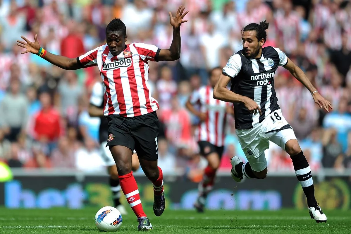 Asamoah Gyan of Sunderland in action with Jonas Gutierrez of Newcastle United during the Barclays Premier League match between Sunderland and Newcastle United