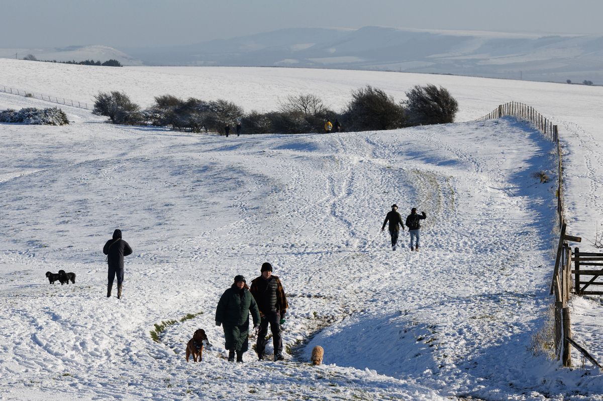 Walkers enjoy the snow at Ditchling Beacon on January 09, 2025 in Ditchling, United Kingdom.