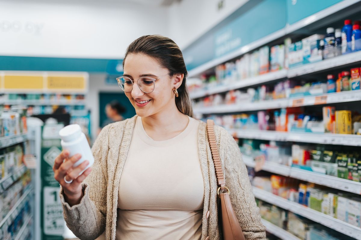 A woman chooses supplements at a pharmacy