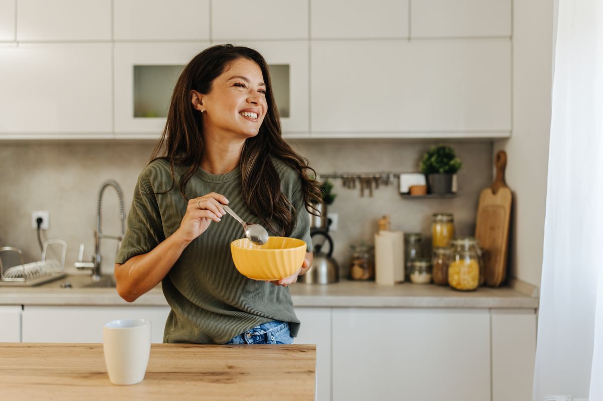 A woman eating in a kitchen