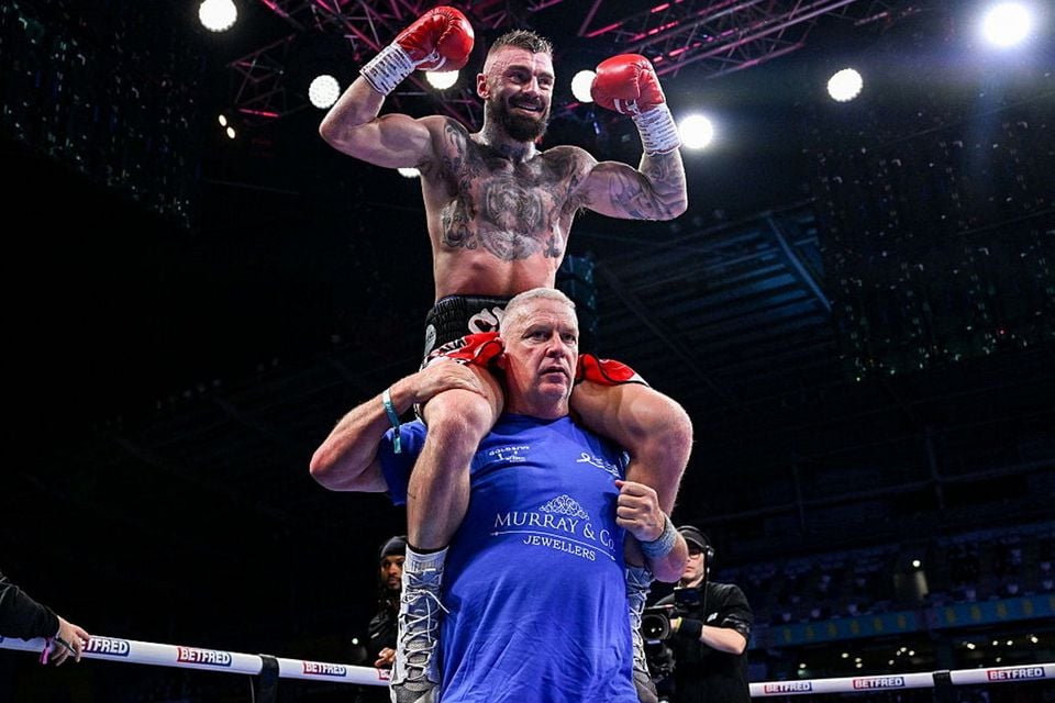 Coach Billy Nelson hoists Lewis Crocker high after his win over Paddy Donovan