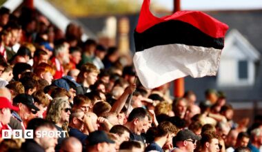 Exeter City fans wave a red, black and white-striped flag