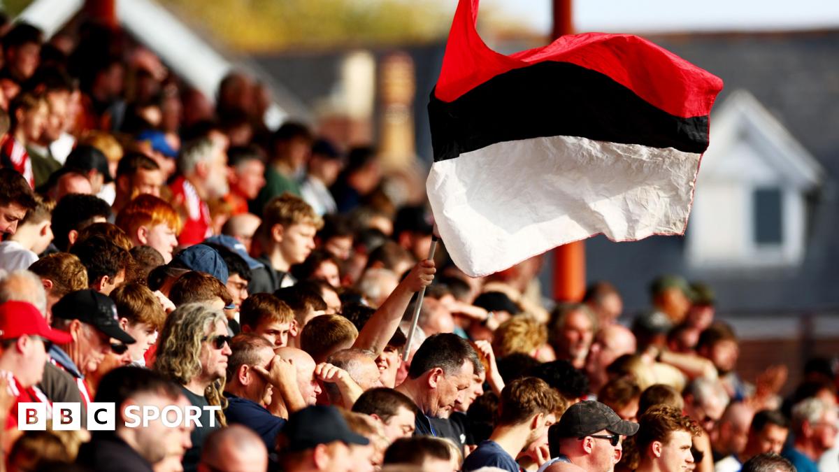 Exeter City fans wave a red, black and white-striped flag