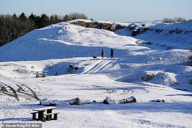 People walk through a snow-covered Burton Dassett Hills Country Park in Warwickshire