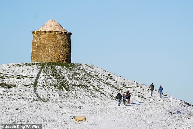 People walk through a snow-covered Burton Dassett Hills Country Park amid the cold weather