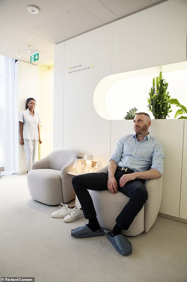 He waits for his scan in a modern-looking lounge - and is even given special slippers to wear