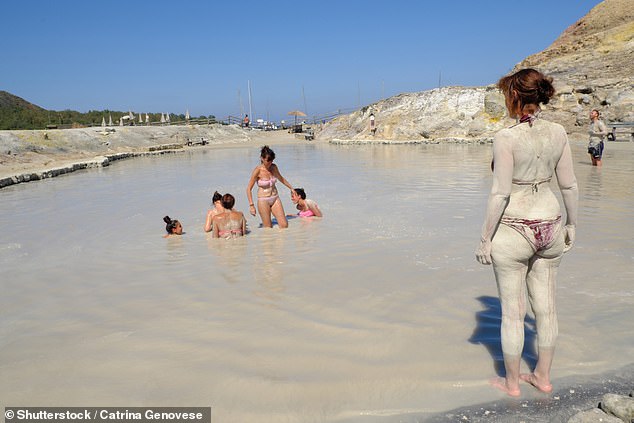 Tourists are pictured enjoying the hot mud baths (Laghetto di Fanghi) on the Aeolian Islands, Sicily, Italy