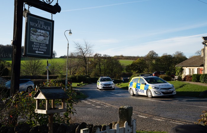 Two police cars drive through Emmerdale village
