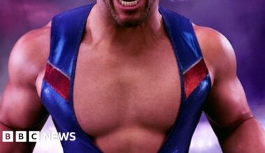 A man flexes his muscles in a tight leotard which is open at the chest