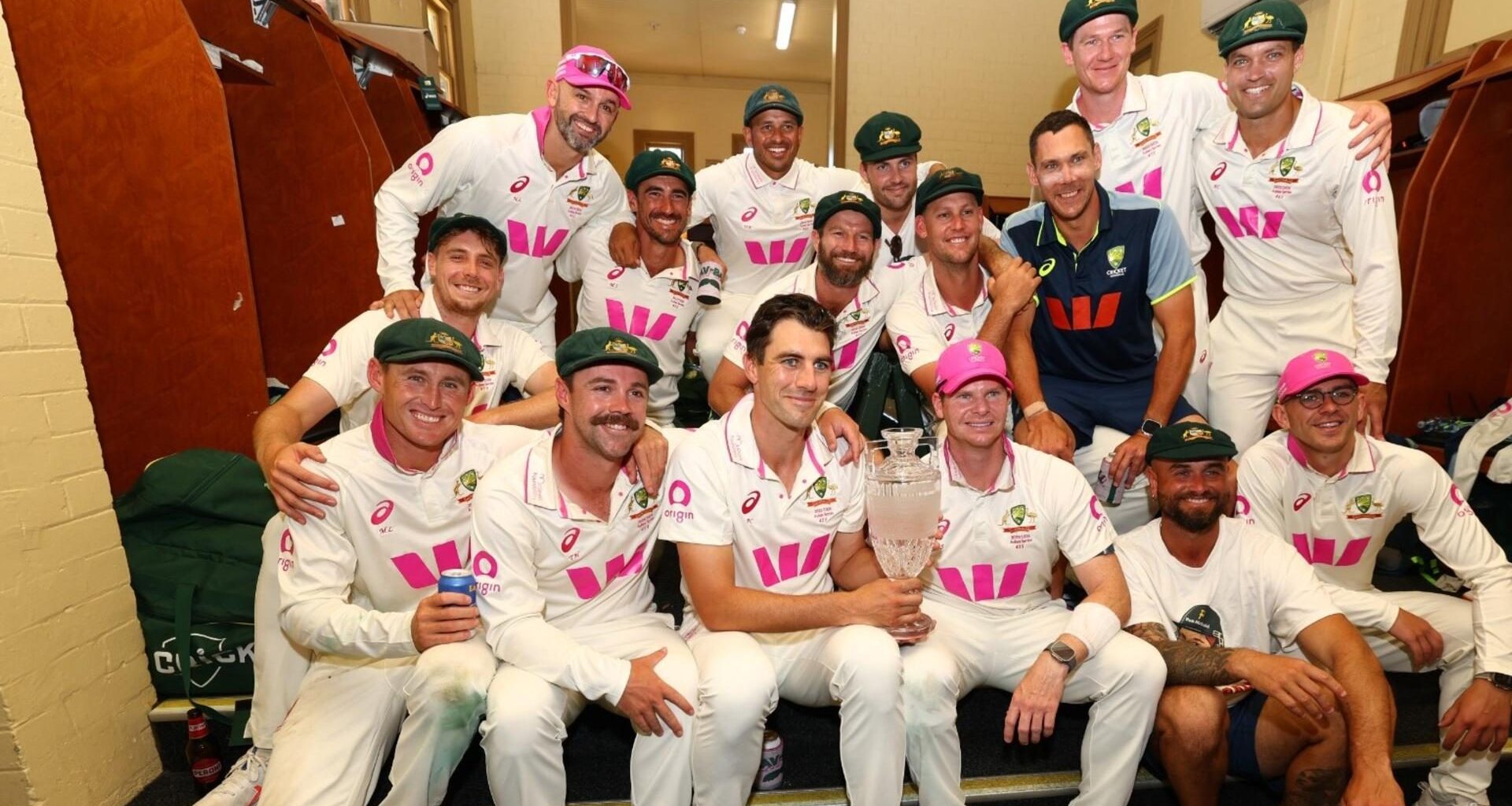 Australia players pose with the Ashes trophy in the SCG dressing rooms