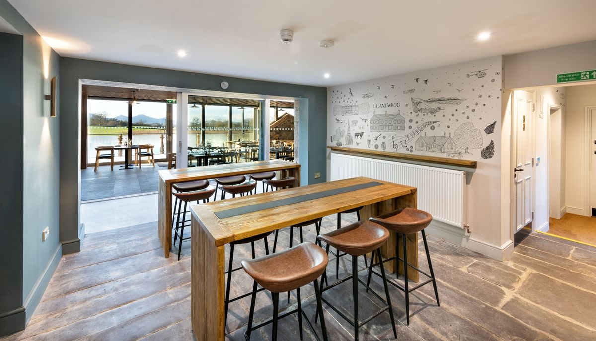 Stepping from the old pub into the new you are greeted by this amazing view - inside and out at The renovation, conversion and transformation of T'yn Llan commnity pub in Llandwrog, Gwynedd this is the new build extension with restaurant, catering kitchen, facilities and community room