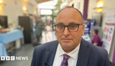 Ifti Majid, chief executive of Nottinghamshire Healthcare NHS Foundation Trust, is pictured wearing black-rimmed glasses, a dark blue suit, white shirt and tie