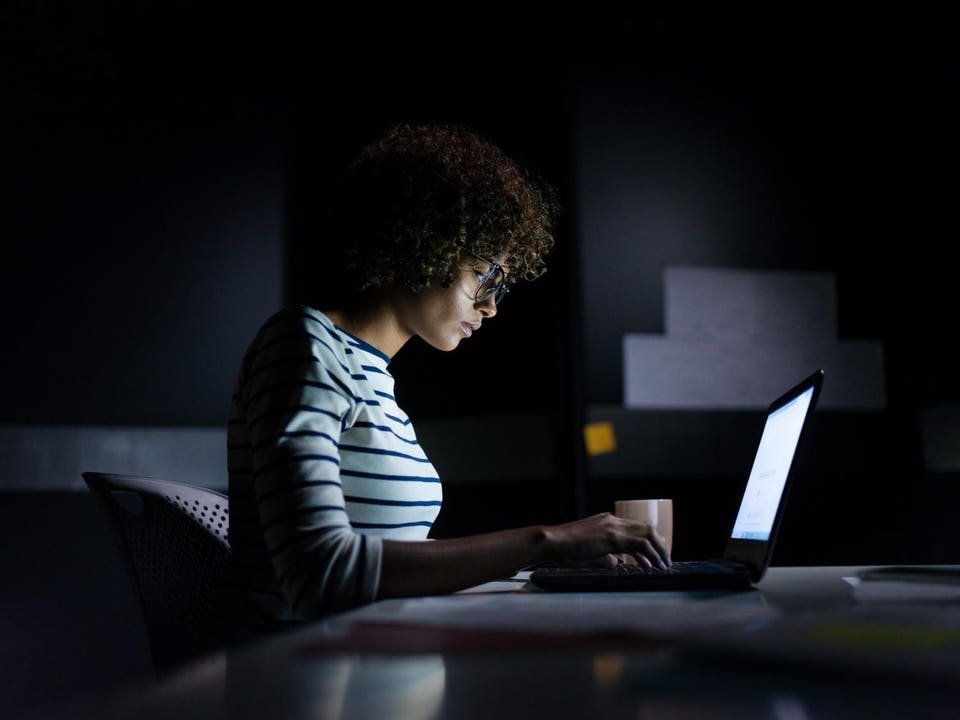 Concentrated businesswoman working late hours with her laptop