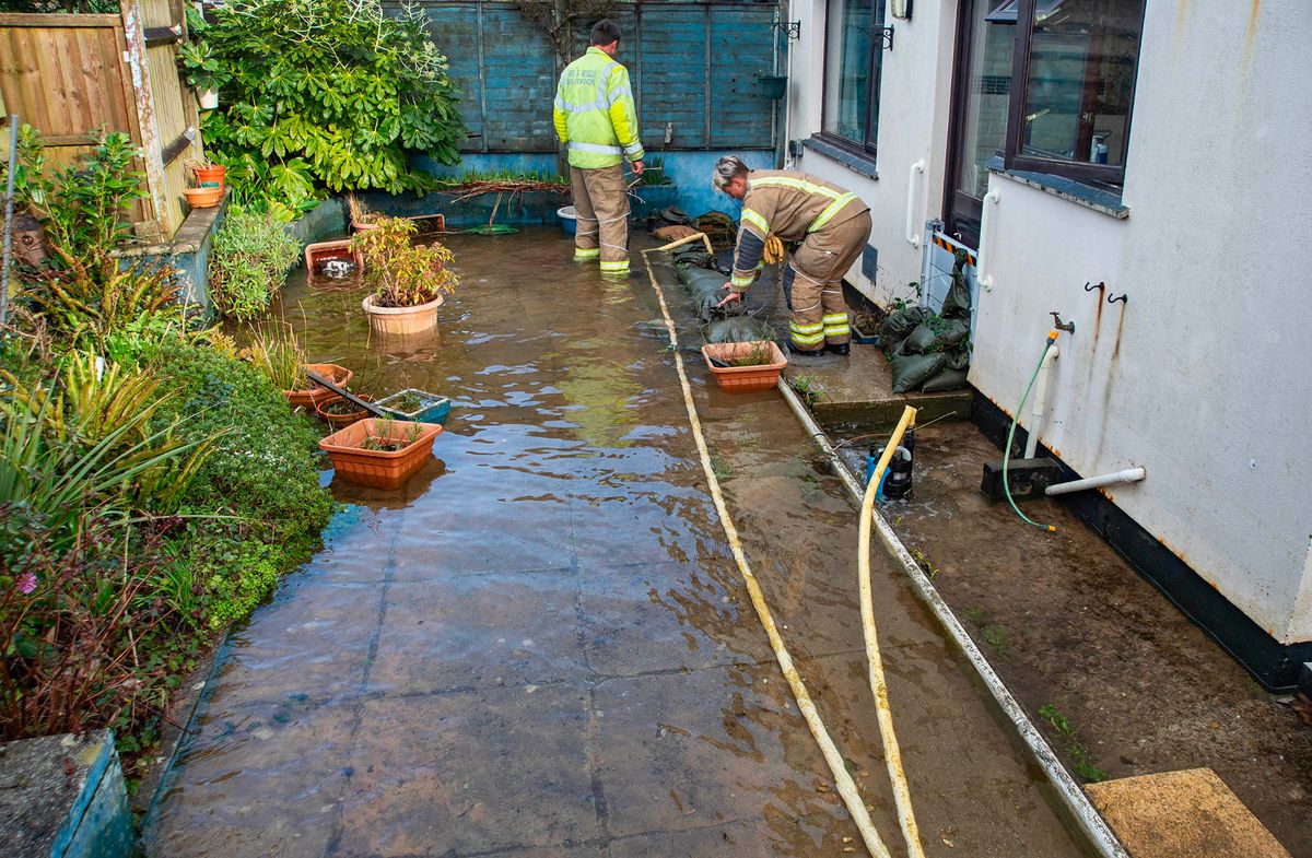 Firefighters tackle the flood in Mr and Mrs Roch's garden