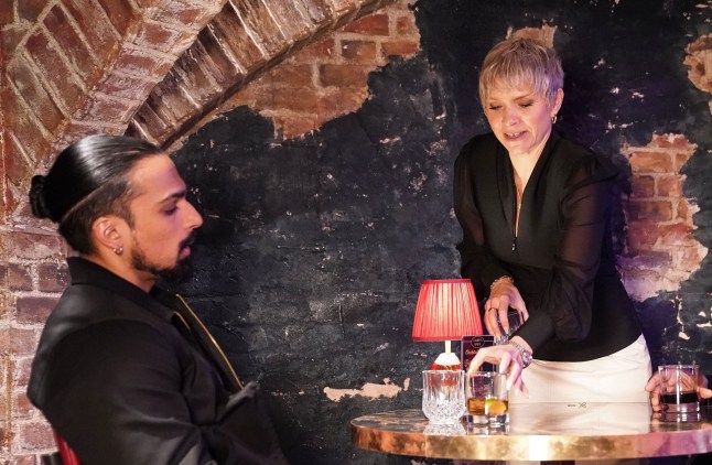 Nicola Mitchell serving Ravi Gulati a drink in Harry's Barn in EastEnders.