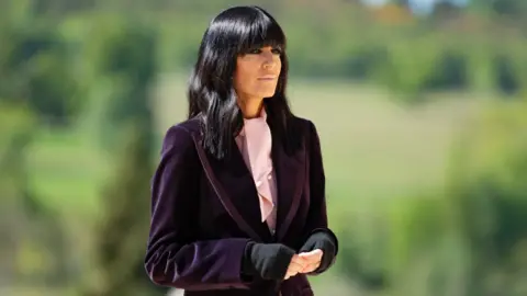 Claudia Winkleman pictured outdoors hosting series four of The Traitors
