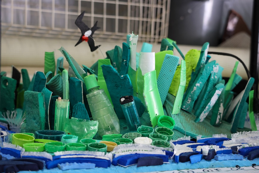 Green and blue pieces of plastic are stuck together with a bird above it.