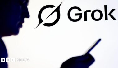 Silhouette of a person holding a smartphone in front of Grok and X logo