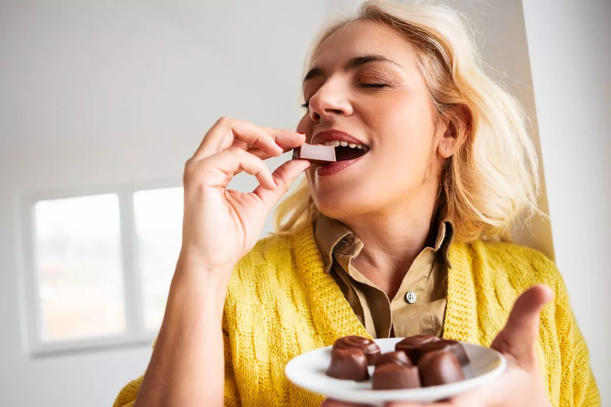 Happy woman eating chocolate
