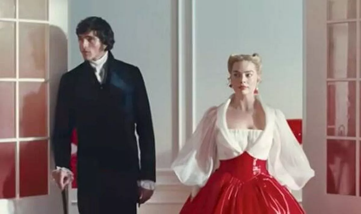 A man in back and a woman in white and red walk