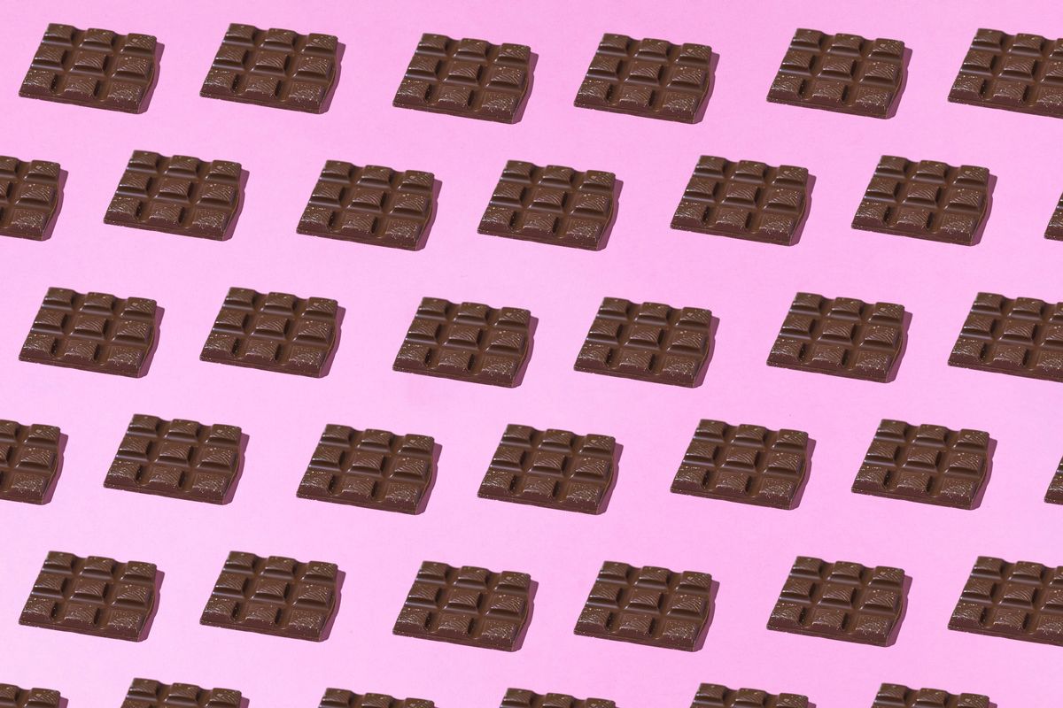 Chocolate tablets pattern with hard shadow on pink background. Group, design and sweet concept