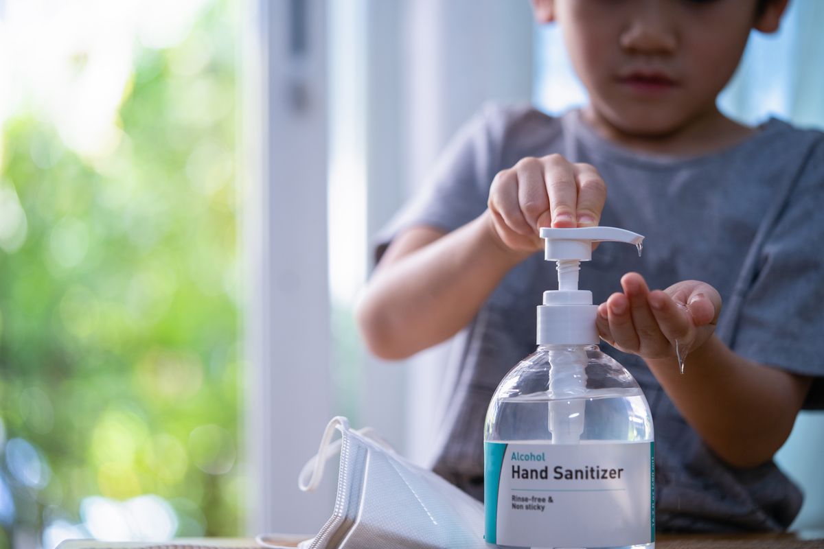 Child Hands Using Wash Hand Sanitizer Gel.