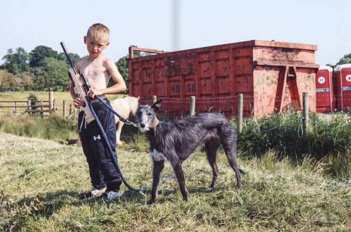 A young boy with a goat at a traveller fair.