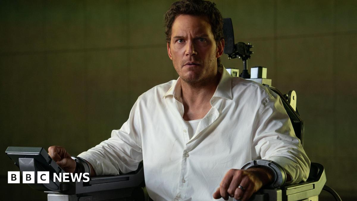 Chris Pratt locked in an executioner's chair, he's in a white shirt and looks very concerned