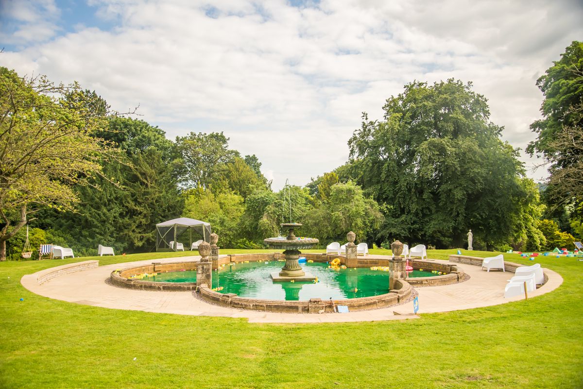 An ornamental fountain filled with yellow rubber ducks