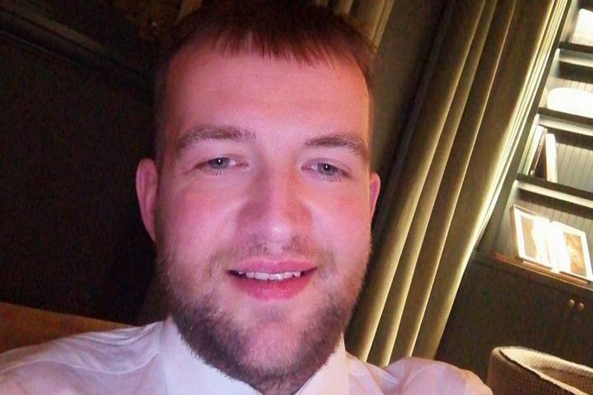 An man with a beard and mustache, dressed in a white shirt 