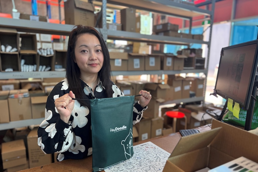 a woman in a factory with boxes and a bag