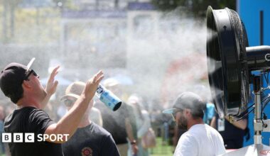 A man stands in front of a water mister in Melbourne Park