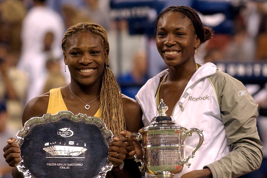 Venus and Serena Williams hold their trophies from the 2001 US Open final.