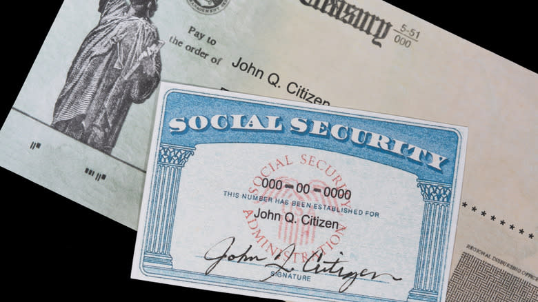 Social Security card and check on black background