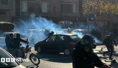 A cloud of tear gas floats across a road as cars and motorcycles pass through it, in Tehran (25/12/25)